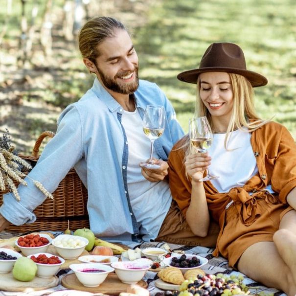 IT - Coppia che fa picnic tra i vigneti delle Langhe. EN - Couple enjoying a picnic among the Langhe vineyards.