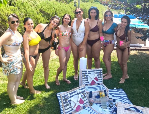 Gruppo di ragazze in piscina con cestini picnic Cappuccetto Verde durante un addio al nubilato nel Monferrato
